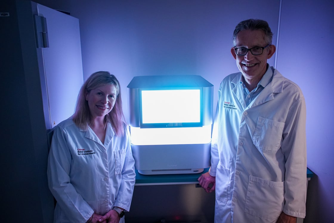 Drs. Laura Goodman and Gary Whittaker stand in front of an illuminated screen